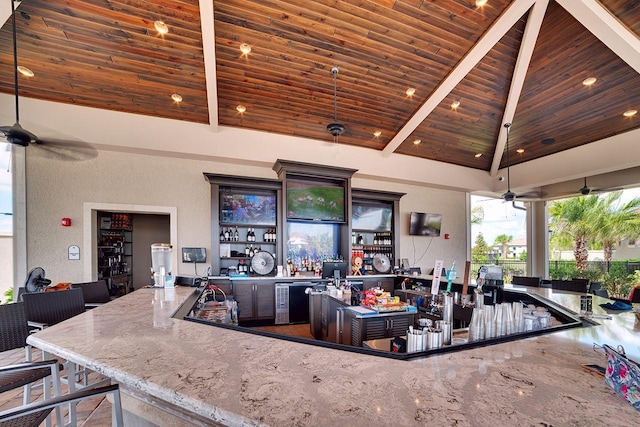 bar with wet bar, wooden ceiling, a ceiling fan, and high vaulted ceiling