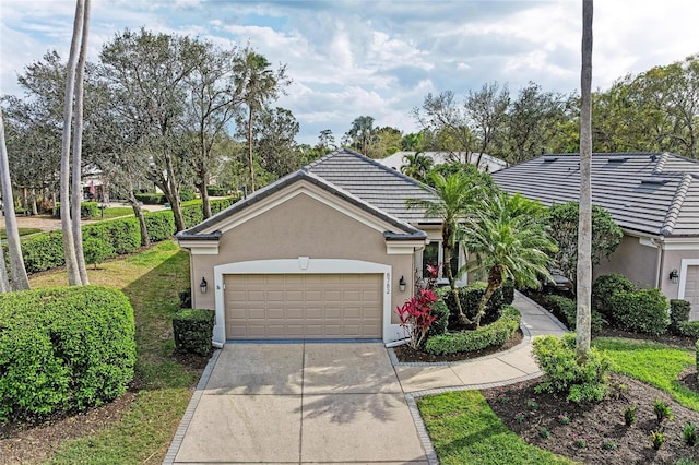 ranch-style home featuring a garage, driveway, a tiled roof, and stucco siding