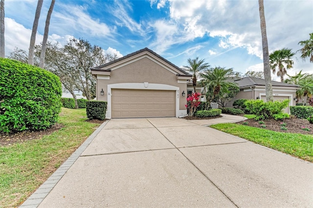 ranch-style home featuring stucco siding, an attached garage, a front yard, driveway, and a tiled roof