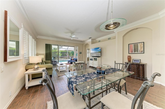 dining room featuring a ceiling fan, crown molding, baseboards, and wood finished floors