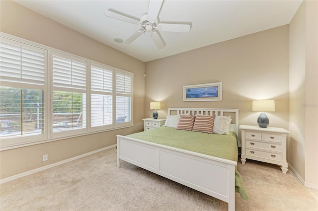 bedroom featuring light colored carpet, ceiling fan, and baseboards