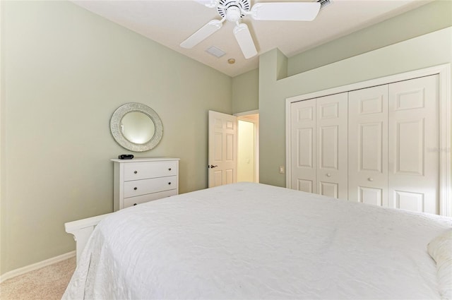 carpeted bedroom with lofted ceiling, ceiling fan, baseboards, and a closet