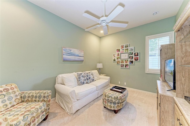 carpeted living area featuring ceiling fan and baseboards