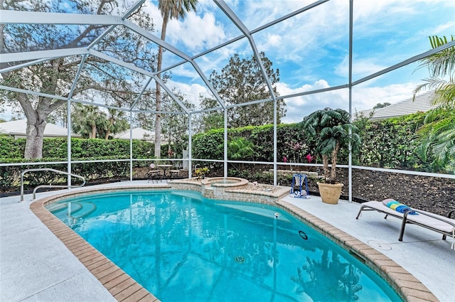 pool with a patio, glass enclosure, and an in ground hot tub