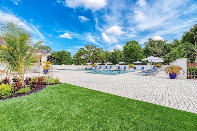 pool with fence, a lawn, and a patio