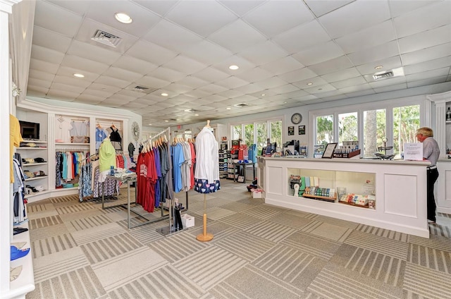 misc room with visible vents, a drop ceiling, and light colored carpet