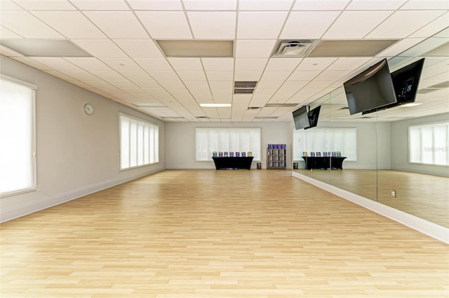 workout room featuring visible vents, baseboards, and wood finished floors