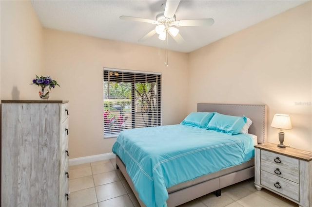 bedroom with a ceiling fan, baseboards, and light tile patterned floors