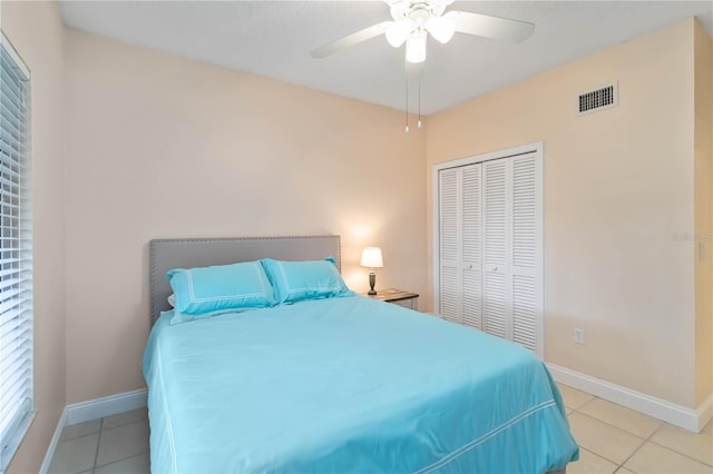 bedroom with light tile patterned floors, a closet, visible vents, and baseboards