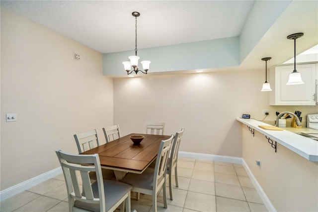 dining space with a chandelier, light tile patterned flooring, and baseboards