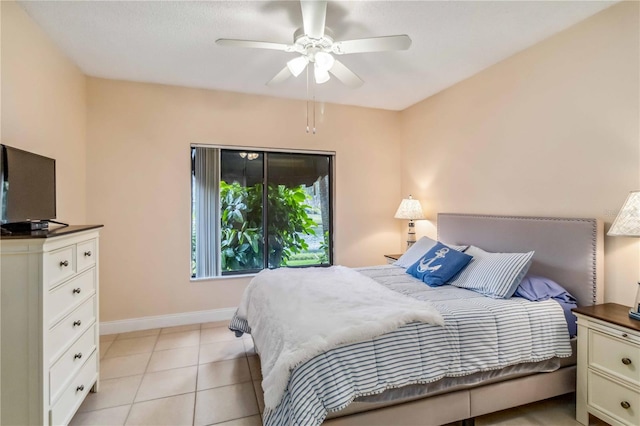 bedroom with ceiling fan, baseboards, and light tile patterned flooring