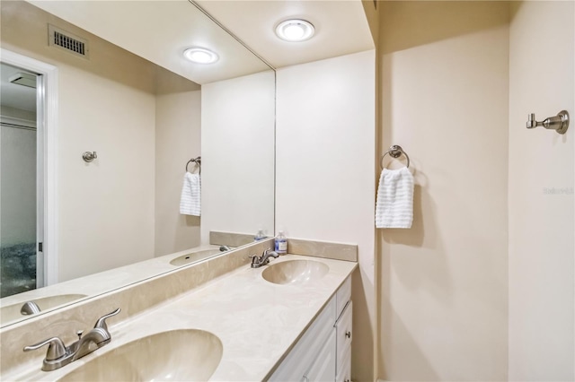 full bath featuring double vanity, a sink, and visible vents