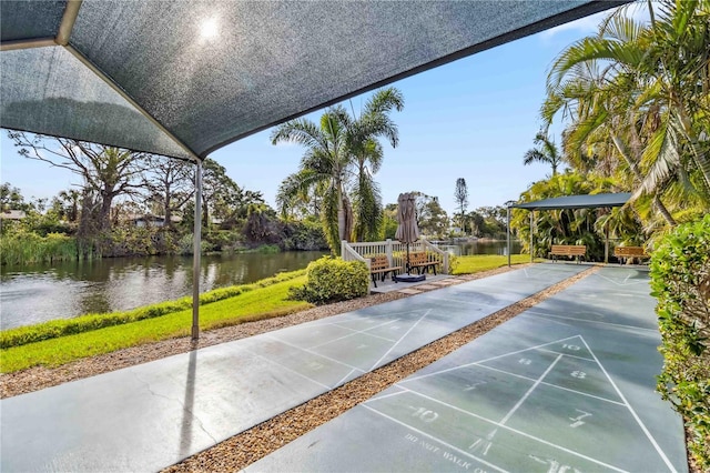 surrounding community with a water view and shuffleboard