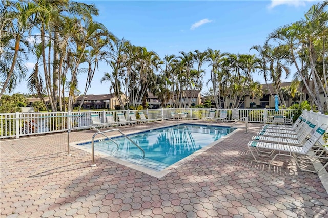 pool with a patio and fence