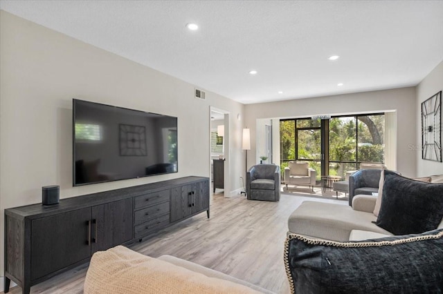 living area with baseboards, recessed lighting, visible vents, and light wood-style floors