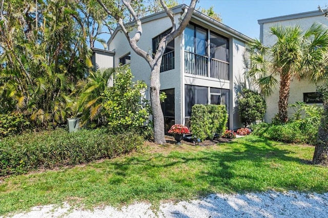 exterior space with a lawn and stucco siding