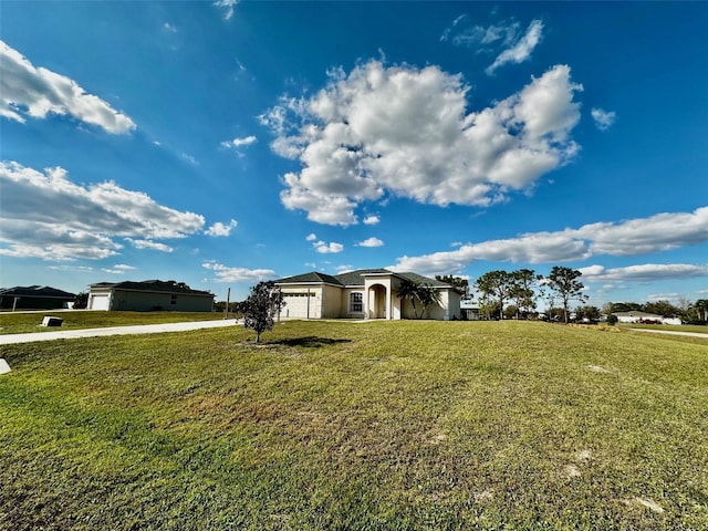 view of front of property with an attached garage, a front lawn, concrete driveway, and stucco siding