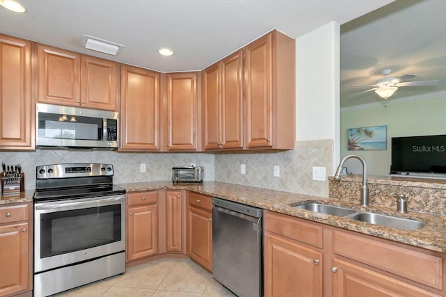 kitchen with light stone counters, visible vents, stainless steel appliances, and a sink