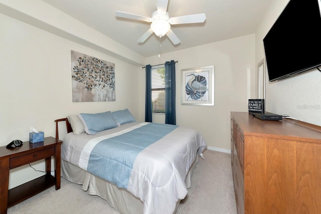 bedroom featuring light carpet, baseboards, and a ceiling fan