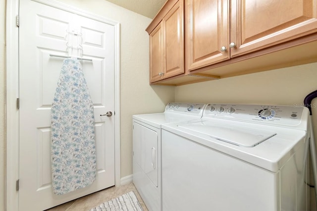 laundry area with cabinet space, light tile patterned floors, and separate washer and dryer