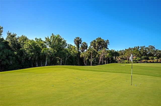 view of home's community featuring view of golf course and a yard