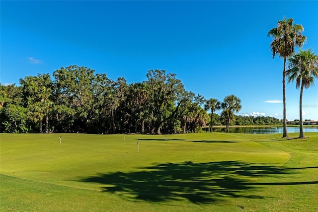 view of community featuring view of golf course, a lawn, and a water view