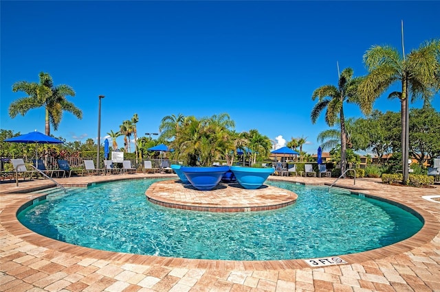 community pool with a patio area and fence