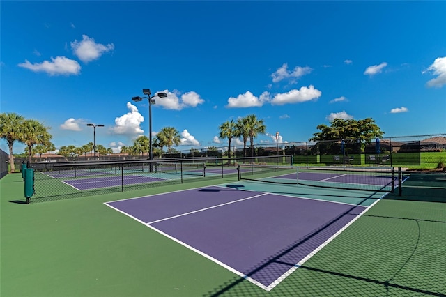 view of tennis court featuring community basketball court and fence