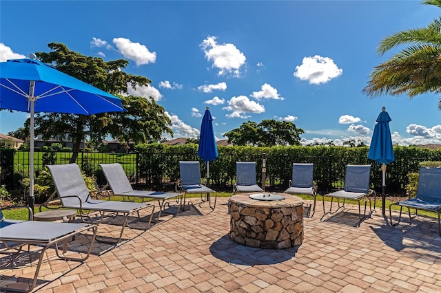 view of patio with an outdoor fire pit and fence