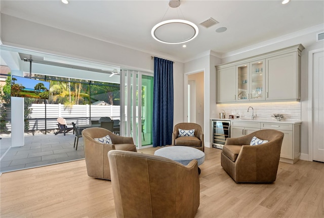 5103 Windward Ave, Sarasota, FL 34242 - living area featuring beverage cooler, wet bar, ornamental molding, light wood-type flooring, and recessed lighting