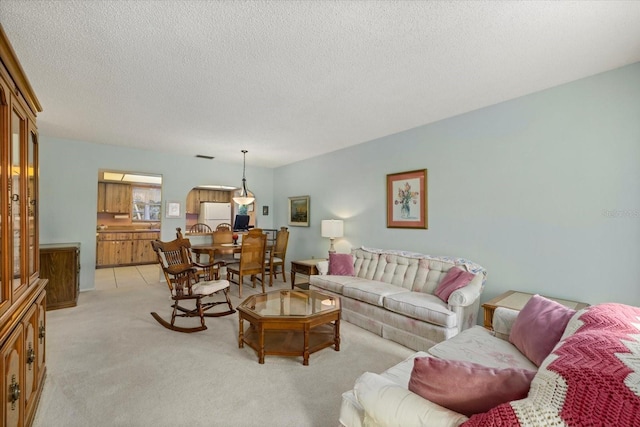 living room featuring light carpet, a textured ceiling, and visible vents