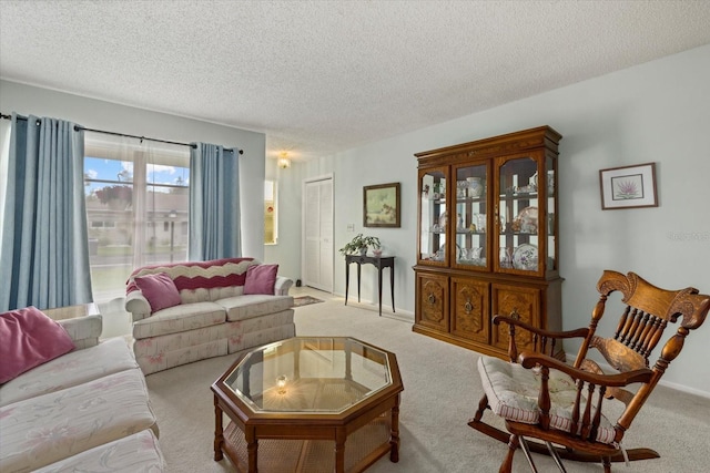 carpeted living room featuring baseboards and a textured ceiling