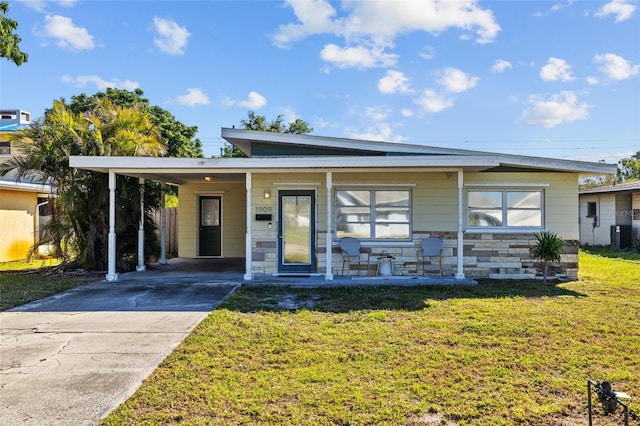 view of front of property featuring a porch, concrete driveway, a front yard, a carport, and stone siding