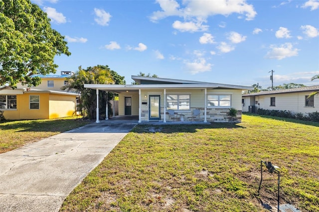 view of front facade featuring stone siding, an attached carport, concrete driveway, and a front yard