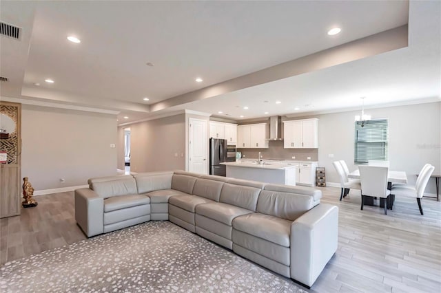 living room with recessed lighting, a raised ceiling, and visible vents