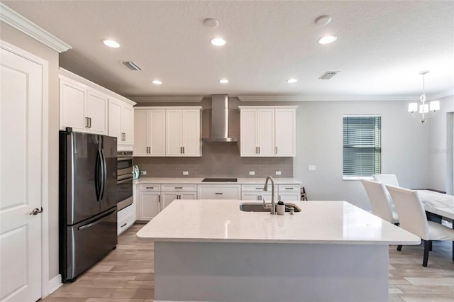 kitchen featuring a sink, visible vents, ornamental molding, wall chimney exhaust hood, and black appliances