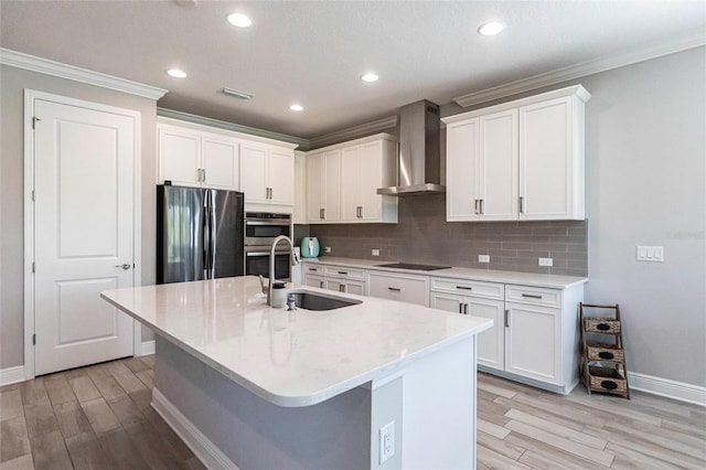 kitchen with tasteful backsplash, visible vents, wall chimney exhaust hood, stainless steel appliances, and a sink