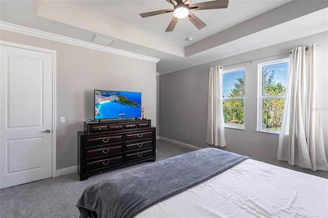 carpeted bedroom with ornamental molding, a tray ceiling, ceiling fan, and baseboards