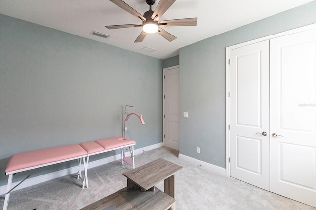 interior space featuring light carpet, ceiling fan, visible vents, and baseboards