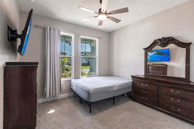 bedroom with light carpet, ceiling fan, and baseboards