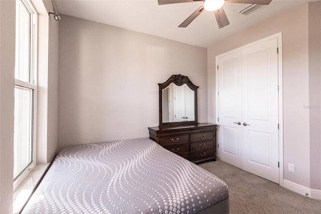 bedroom featuring a ceiling fan, light colored carpet, and baseboards