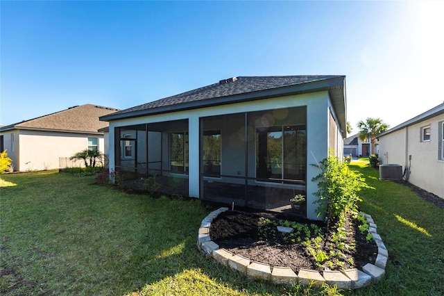 rear view of property featuring a sunroom, stucco siding, a yard, and central air condition unit