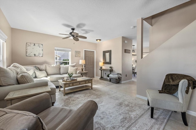 living area featuring light tile patterned flooring, visible vents, and baseboards