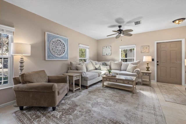 living room with visible vents, ceiling fan, baseboards, and light tile patterned floors