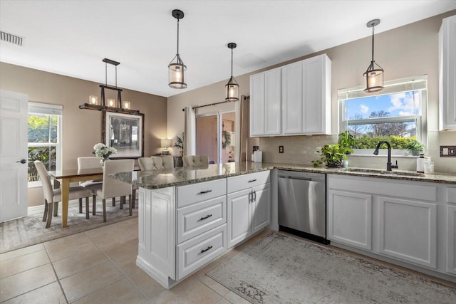 kitchen with visible vents, stainless steel dishwasher, white cabinetry, a sink, and a peninsula