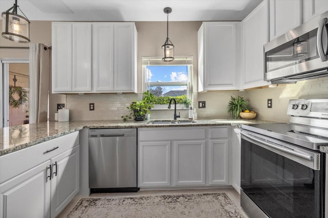 kitchen with white cabinetry, appliances with stainless steel finishes, backsplash, and a sink