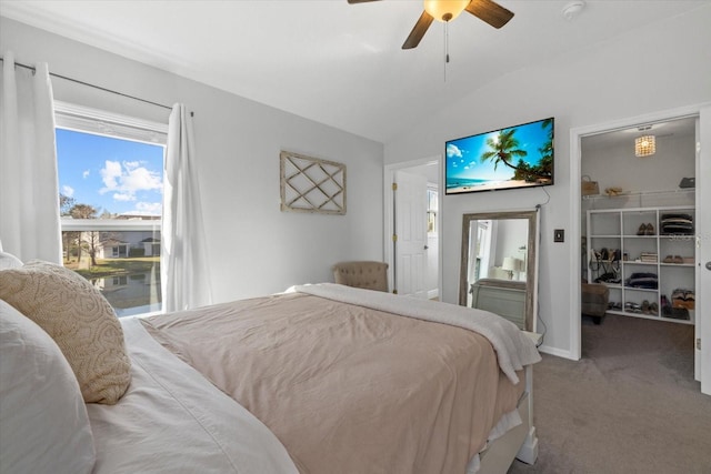 carpeted bedroom featuring ceiling fan, a spacious closet, baseboards, and vaulted ceiling