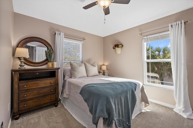 bedroom with ceiling fan, carpet floors, multiple windows, and baseboards