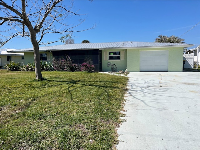 single story home with a garage, metal roof, a front lawn, and stucco siding