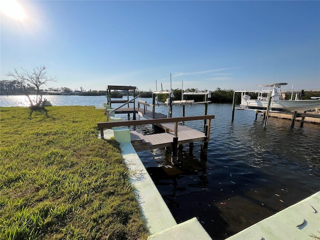 dock area with a yard, a water view, and boat lift